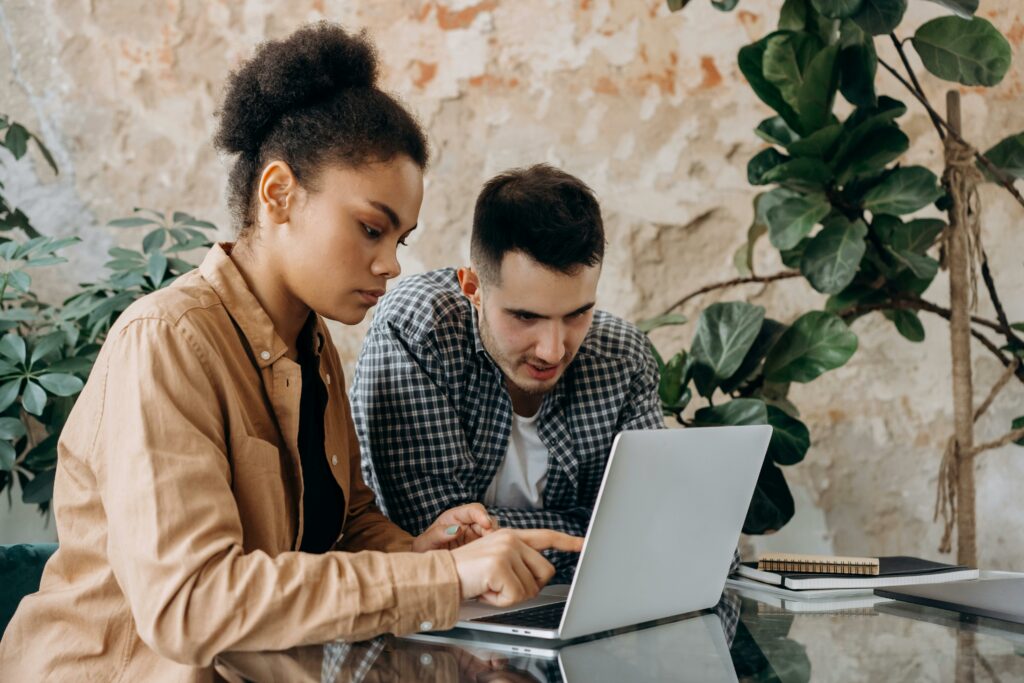 Deux étudiants qui travaillent et regardent un ordinateur portable